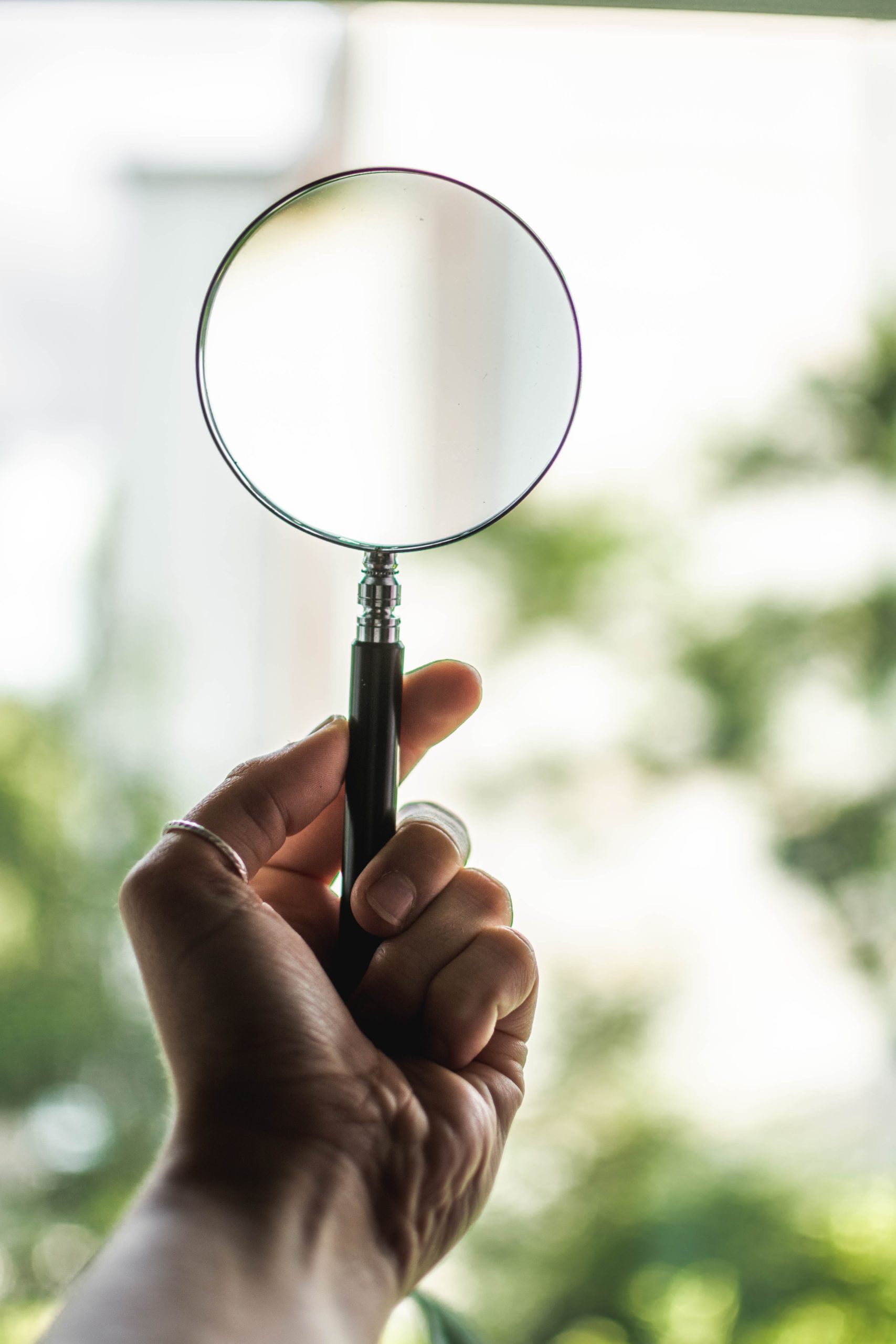 tilt-shift-lens-photography-of-person-holding-magnifying-1192333